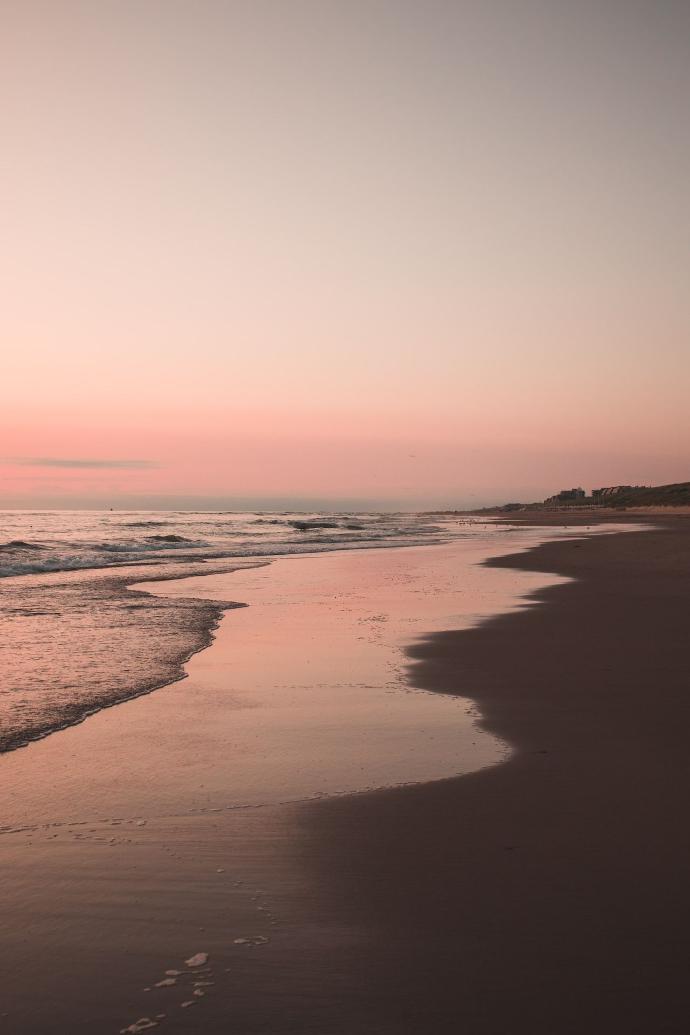 ocean waves crashing on shore during sunset